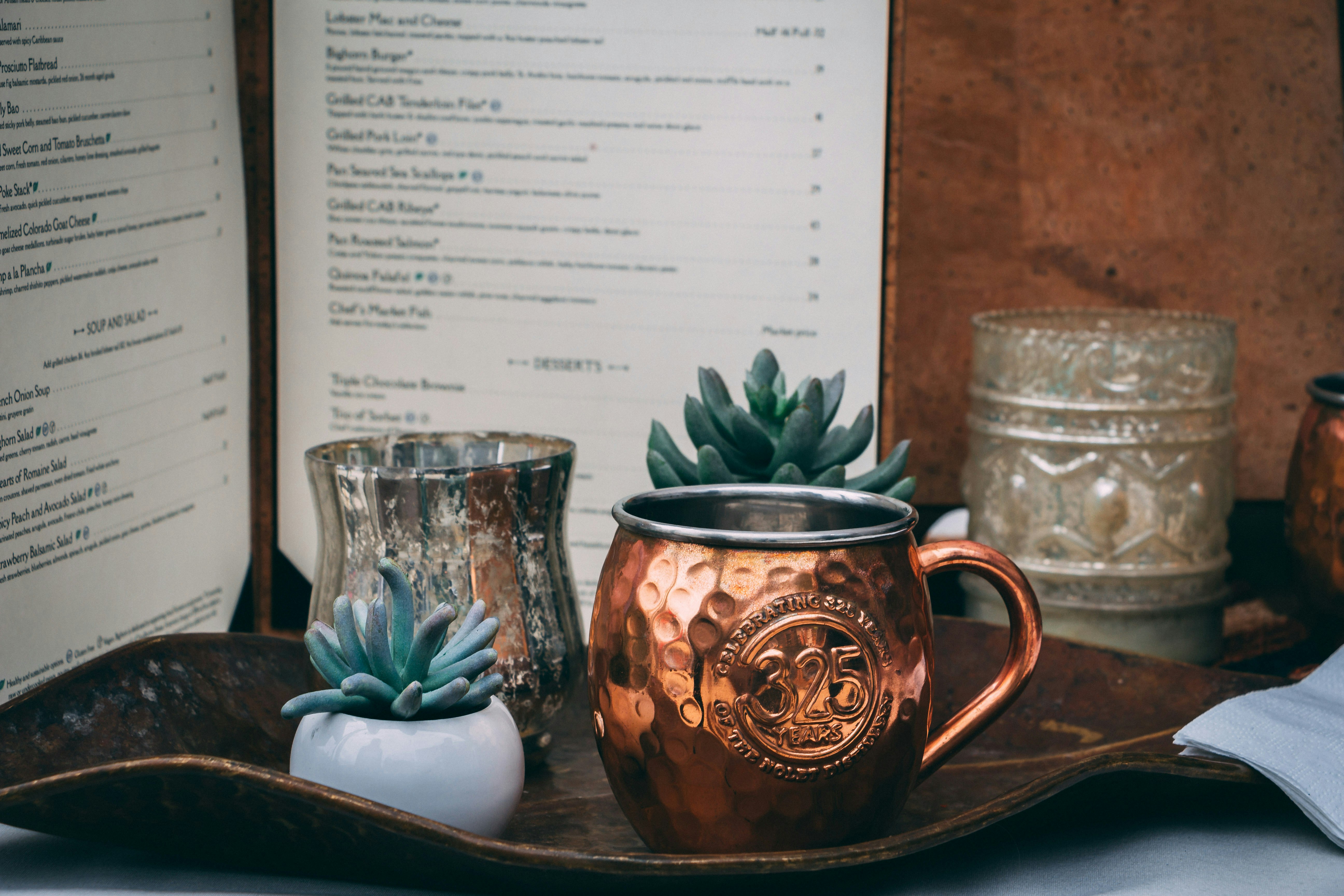 gold cup beside succulent plant on tray